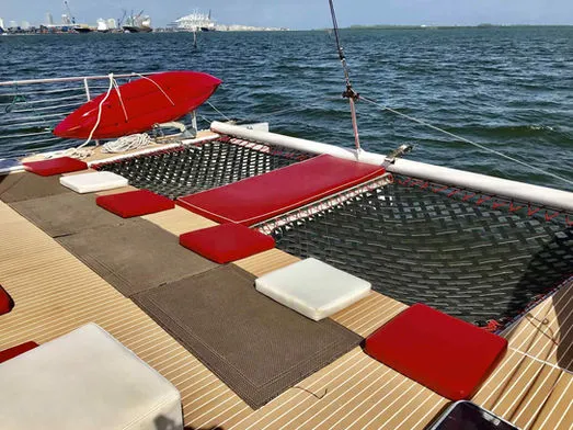 Double-hull catamaran bow trampolines with cushions and red kayak on 60ft Catamaran Mariah