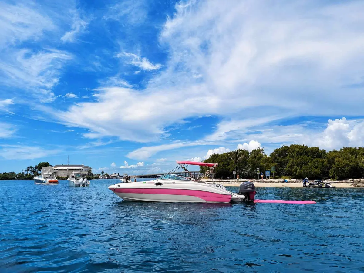 26ft pink Sea Ray Miami anchored off an island with floating mat