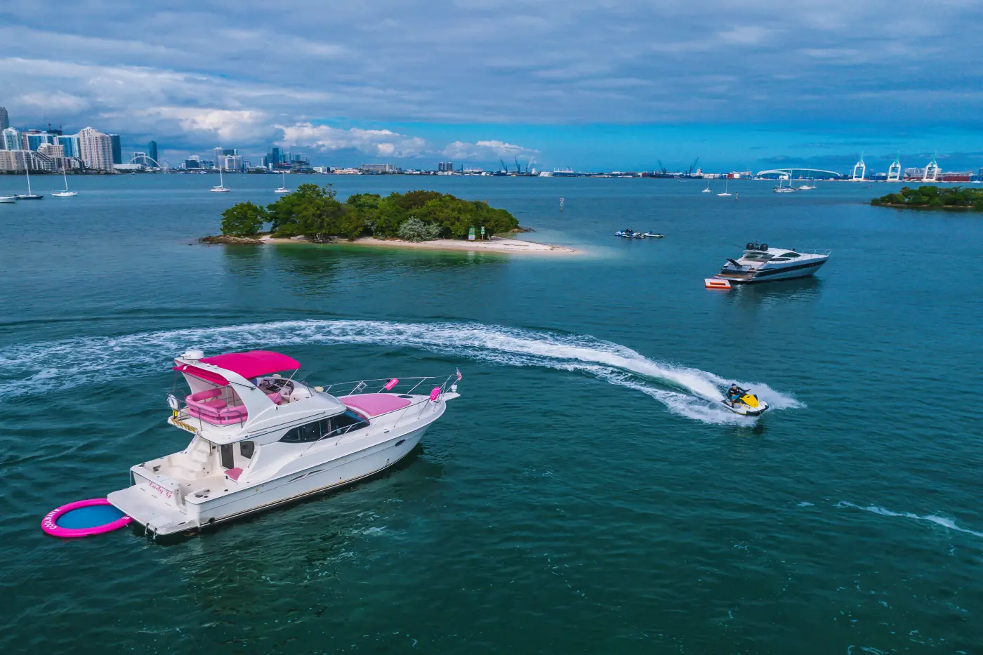 41ft pink Silverton yacht Miami with pink floating mat and a jet ski on Biscayne Bay