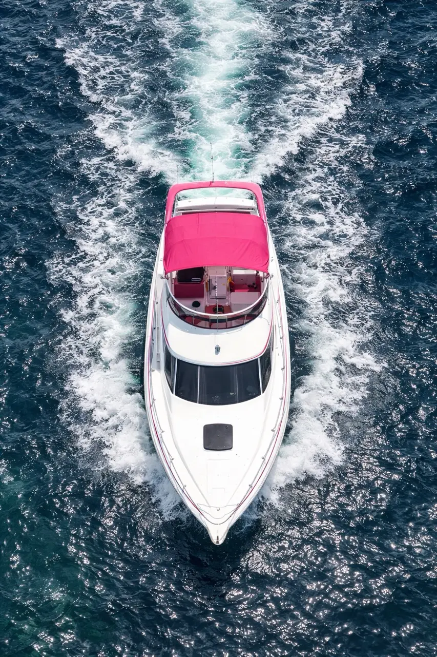 Aerial view of 42ft pink yacht Miami cruising with a white wake