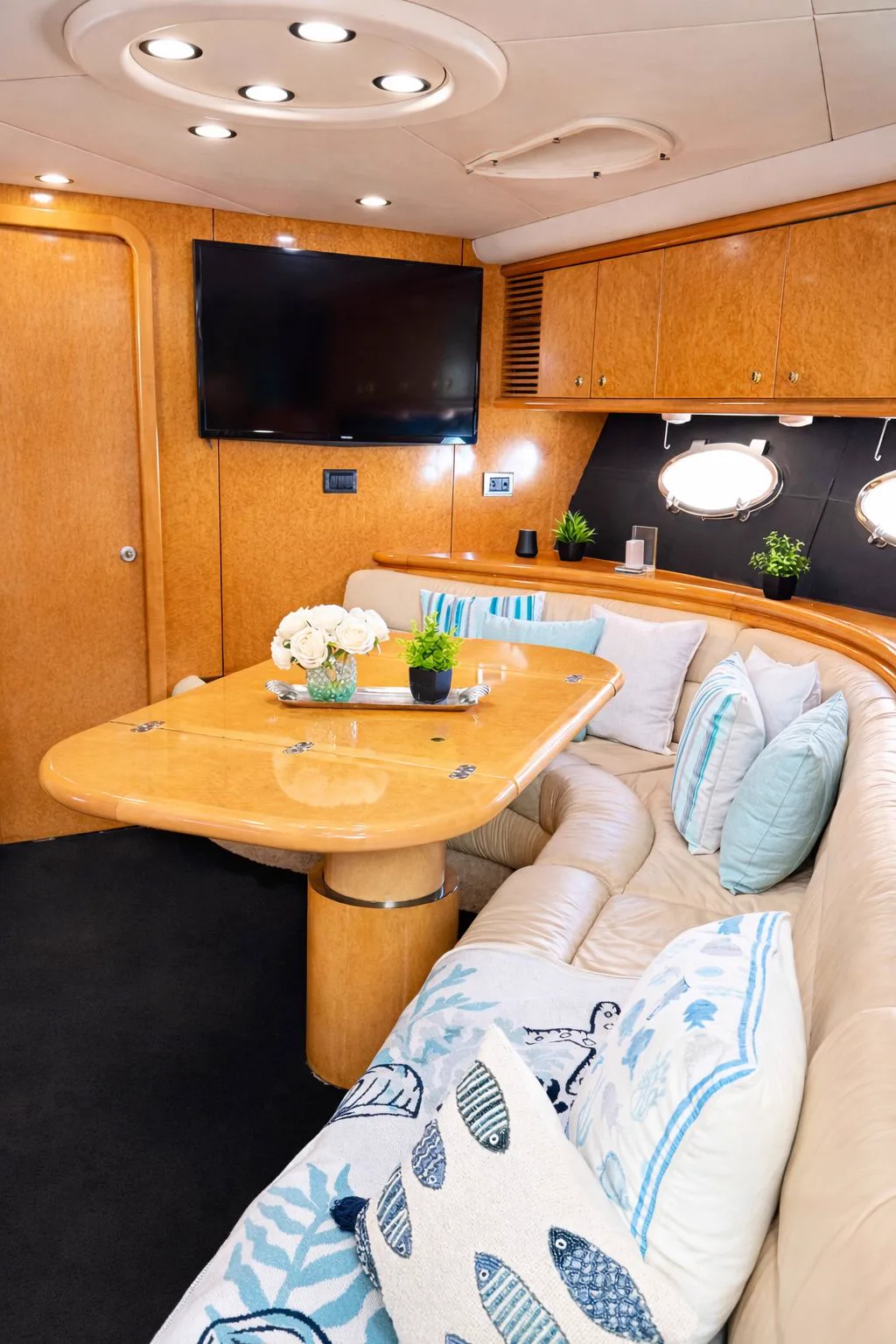 Salon dinette with curved sofa and TV on the 60ft Sunseeker Predator