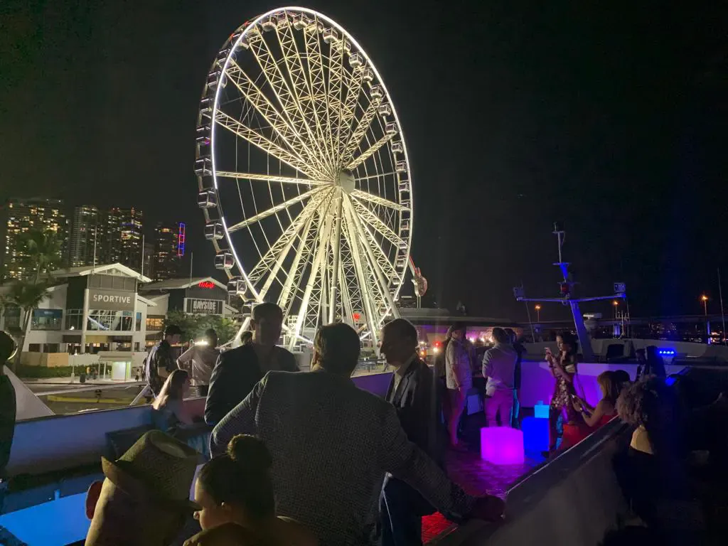 Guests on an open deck at an Art Basel yacht party at night in Downtown Miami