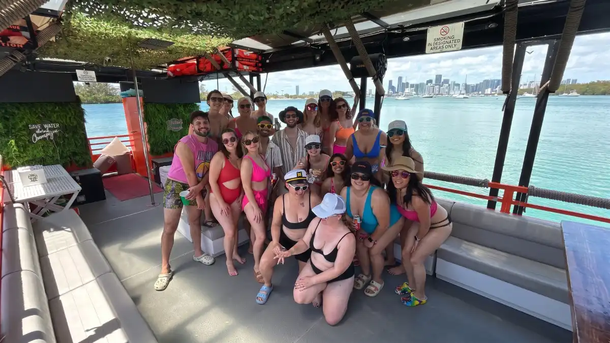 Group celebrating a private party cruise on the 50ft Cat Lux catamaran in Miami with skyline backdrop