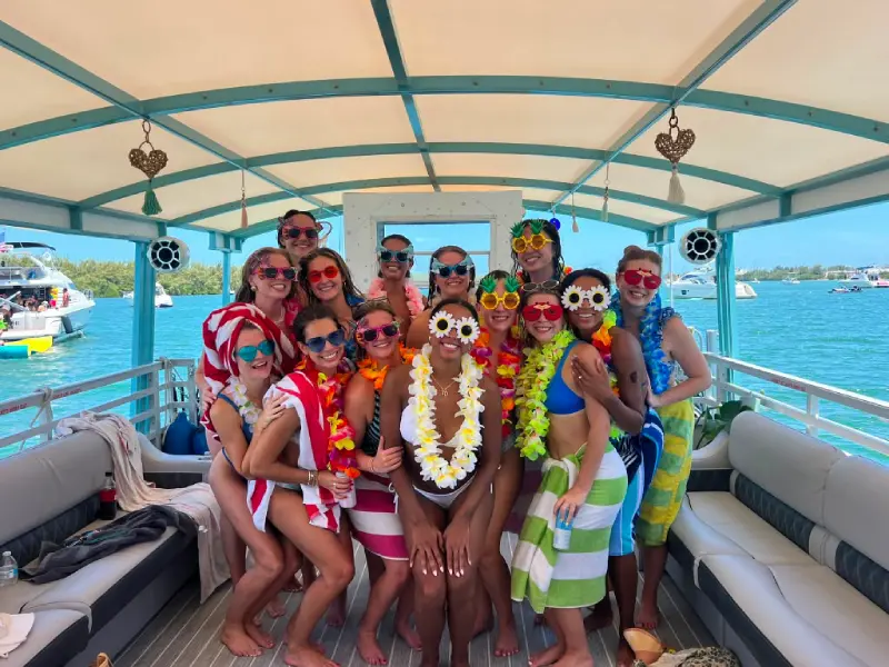 Bachelorette squad wearing colorful flower leis on a private catamaran cruise in Miami