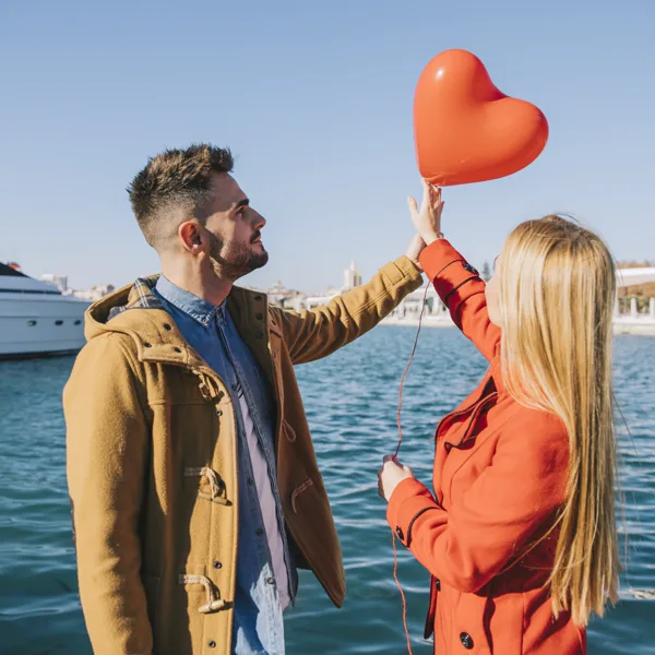 Couple celebrating with red balloons on a Miami yacht rental anniversary