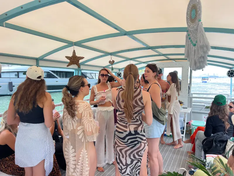 Guests socializing under boho shaded deck canopy on 35ft Moana Flow private boat rental Miami