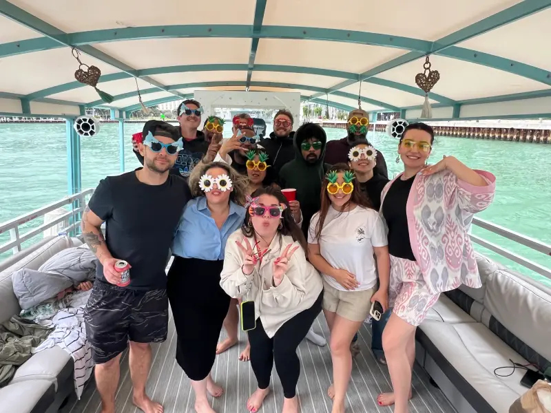 Friends with novelty party glasses on 35ft Moana Flow party boat rental in Miami with captain