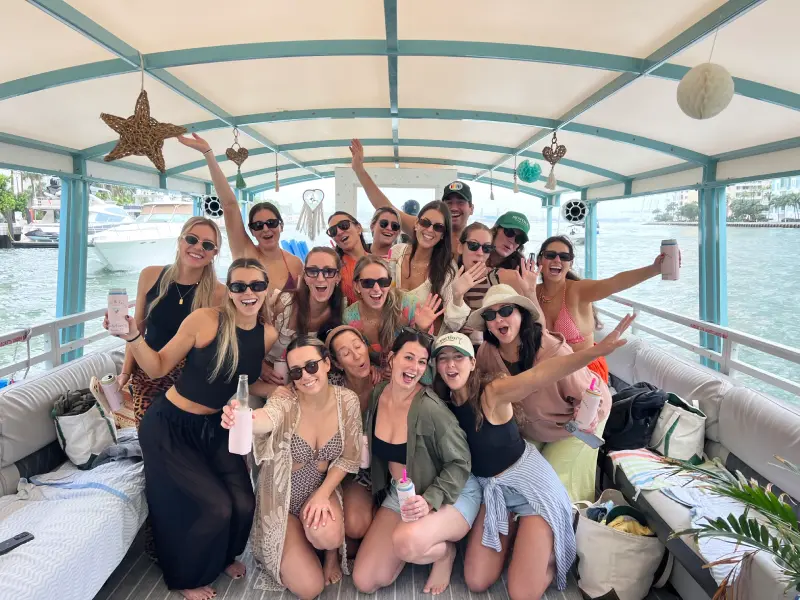 Friends cheering and raising drinks on 35ft Moana Flow party boat cruise in Miami Beach