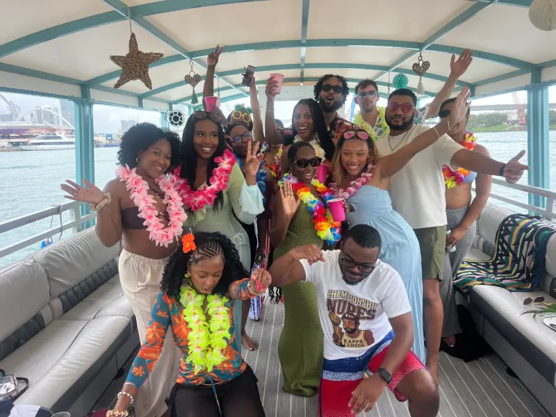 Group dancing with tropical floral leis on 35ft Moana Flow private boat tour in Miami