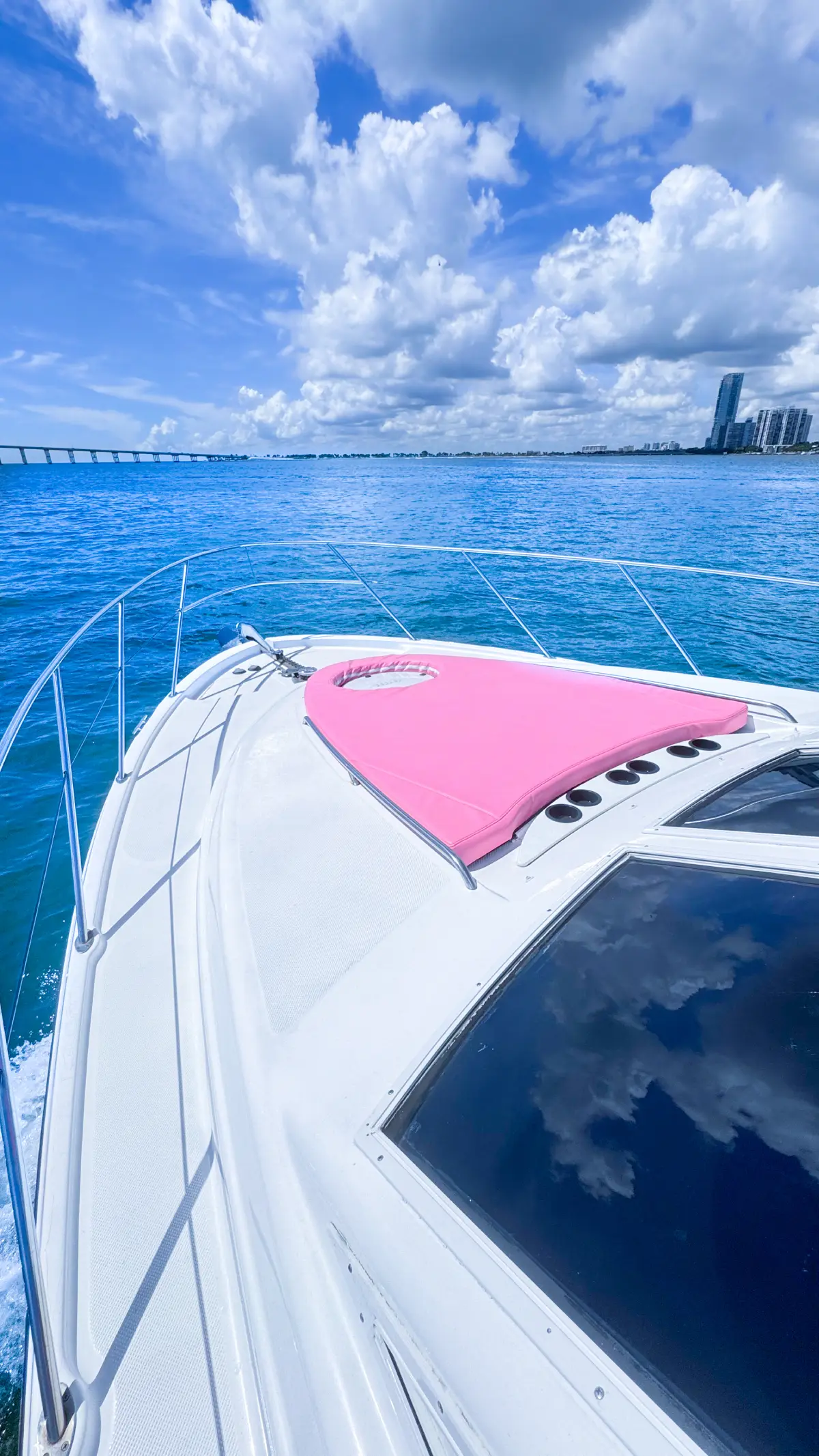 Bow of pink Maxum yacht Miami on Biscayne Bay under blue sky