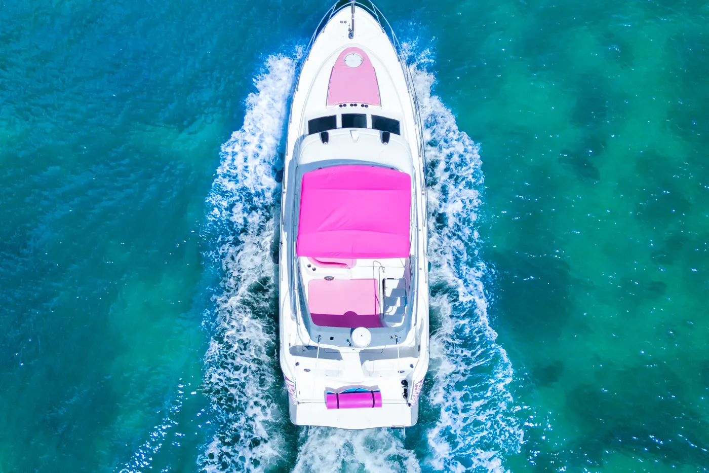 Overhead view of 46ft pink yacht rental Miami leaving a wake on Biscayne Bay