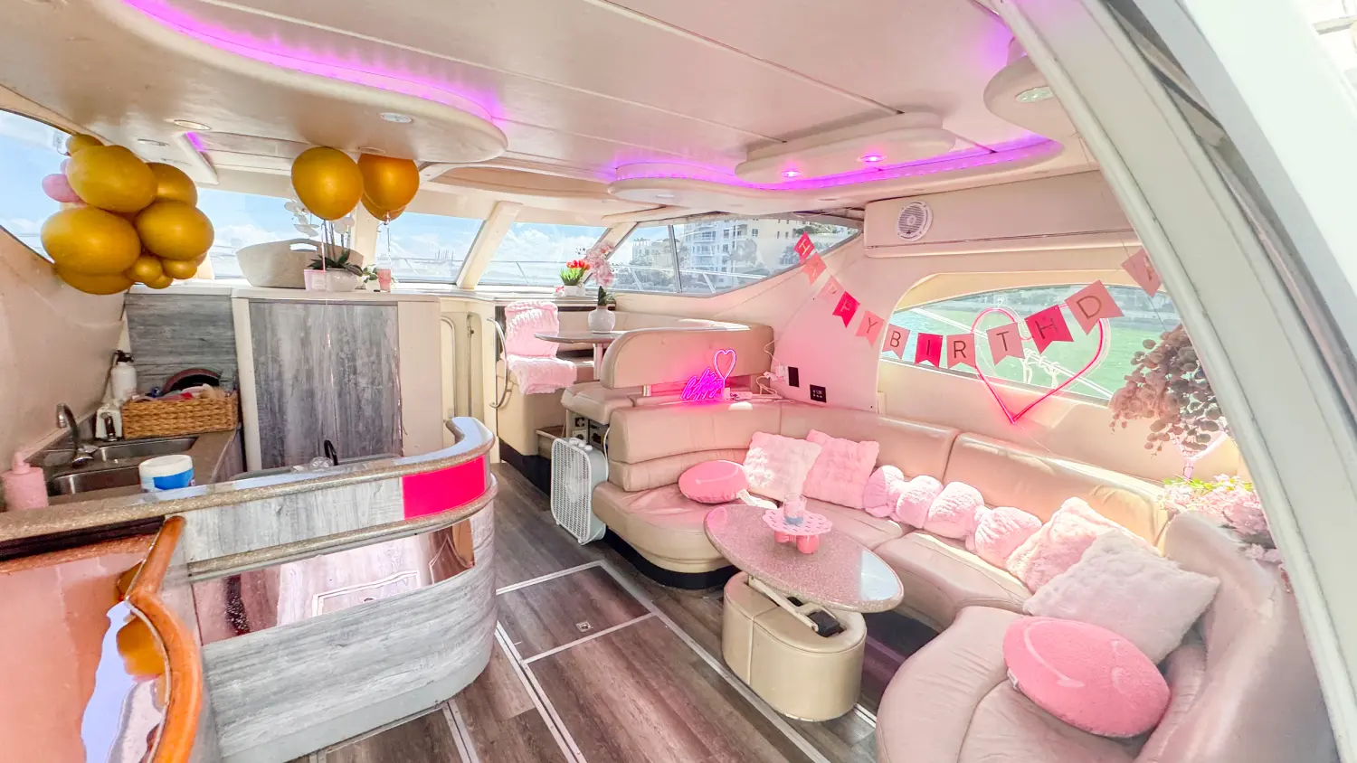 Pink yacht Miami salon and galley with pink neon lights and balloons