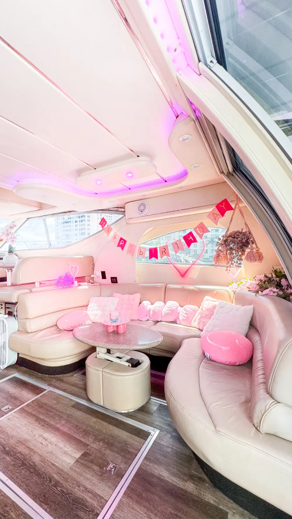 Air-conditioned salon on pink yacht Miami with pink cushions and curved lounge seating