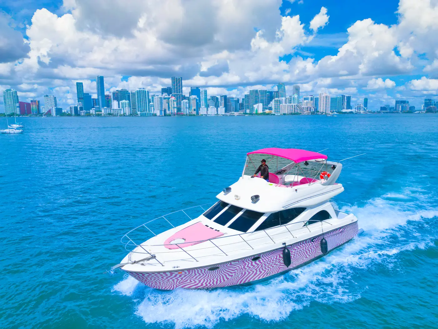 46ft pink yacht rental Miami cruising past the Miami skyline