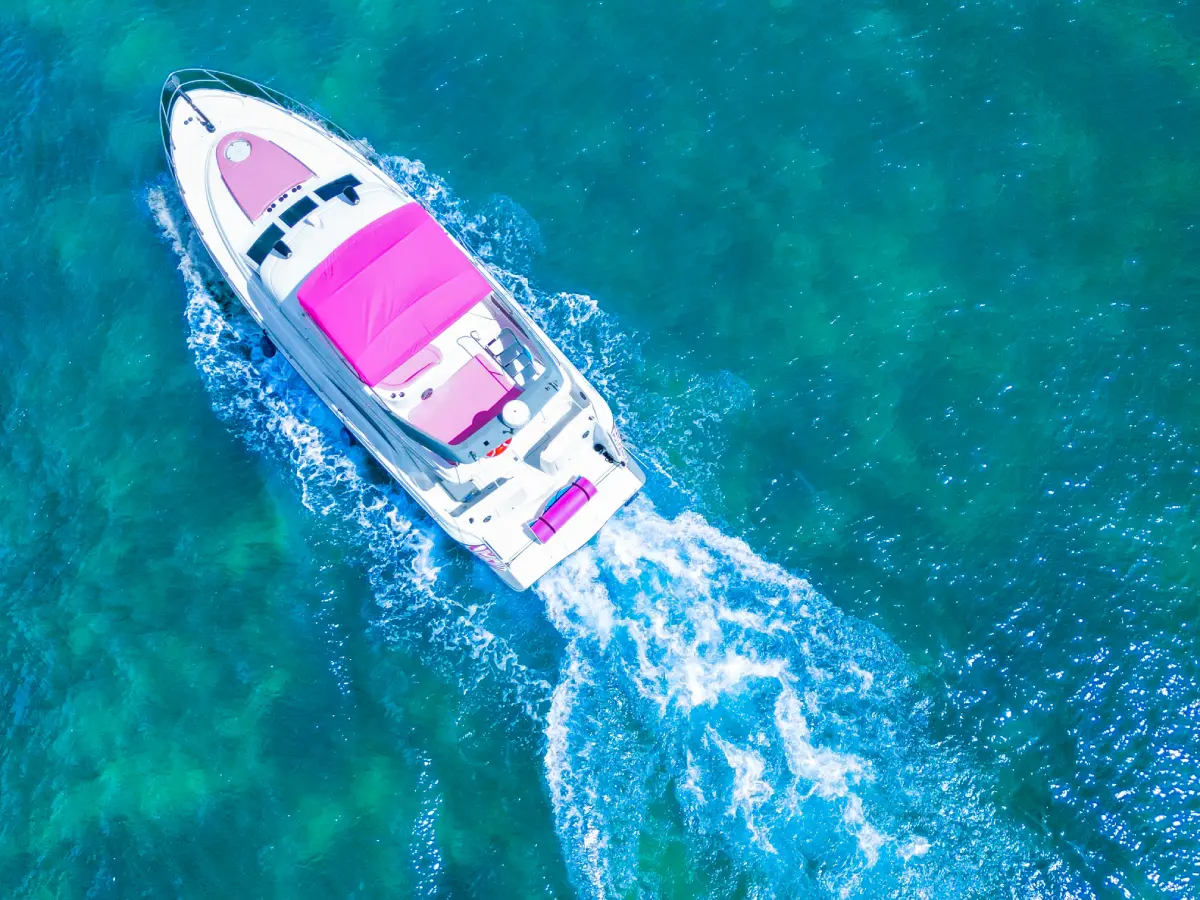 Top down view of pink yacht Miami cruising with pink flybridge canopy